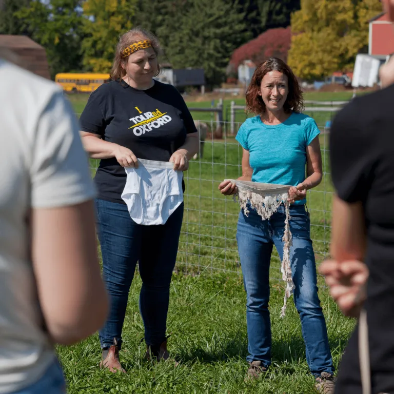 Oxford Tourism team-building session during the Taste of Farm Life experience at Udderly Ridiculous Farm Life, featuring Cheryl demonstrating soil health testing with buried cotton underwear