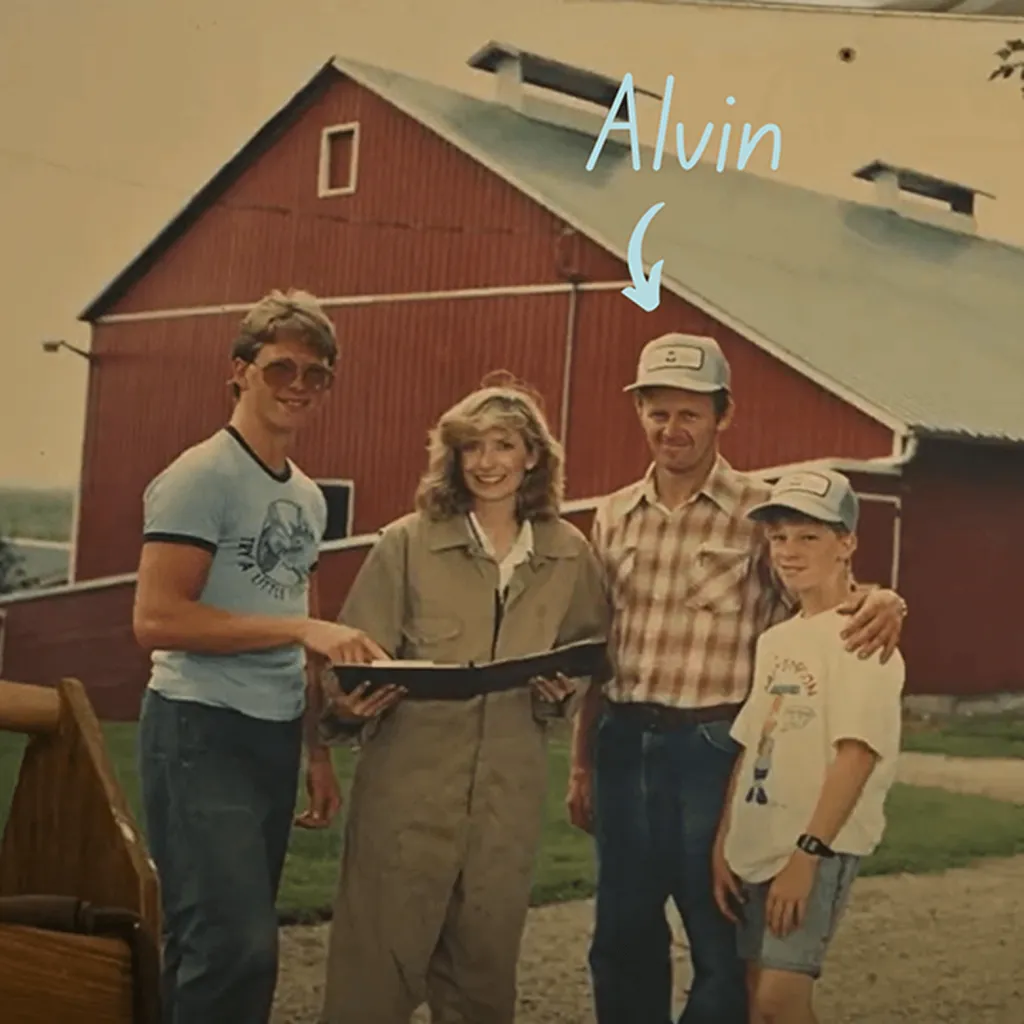 A vintage family photo of Greg’s father, Alvin, alongside his mother and brother, standing in front of the family’s red barn. A tribute to the farm’s deep-rooted history.