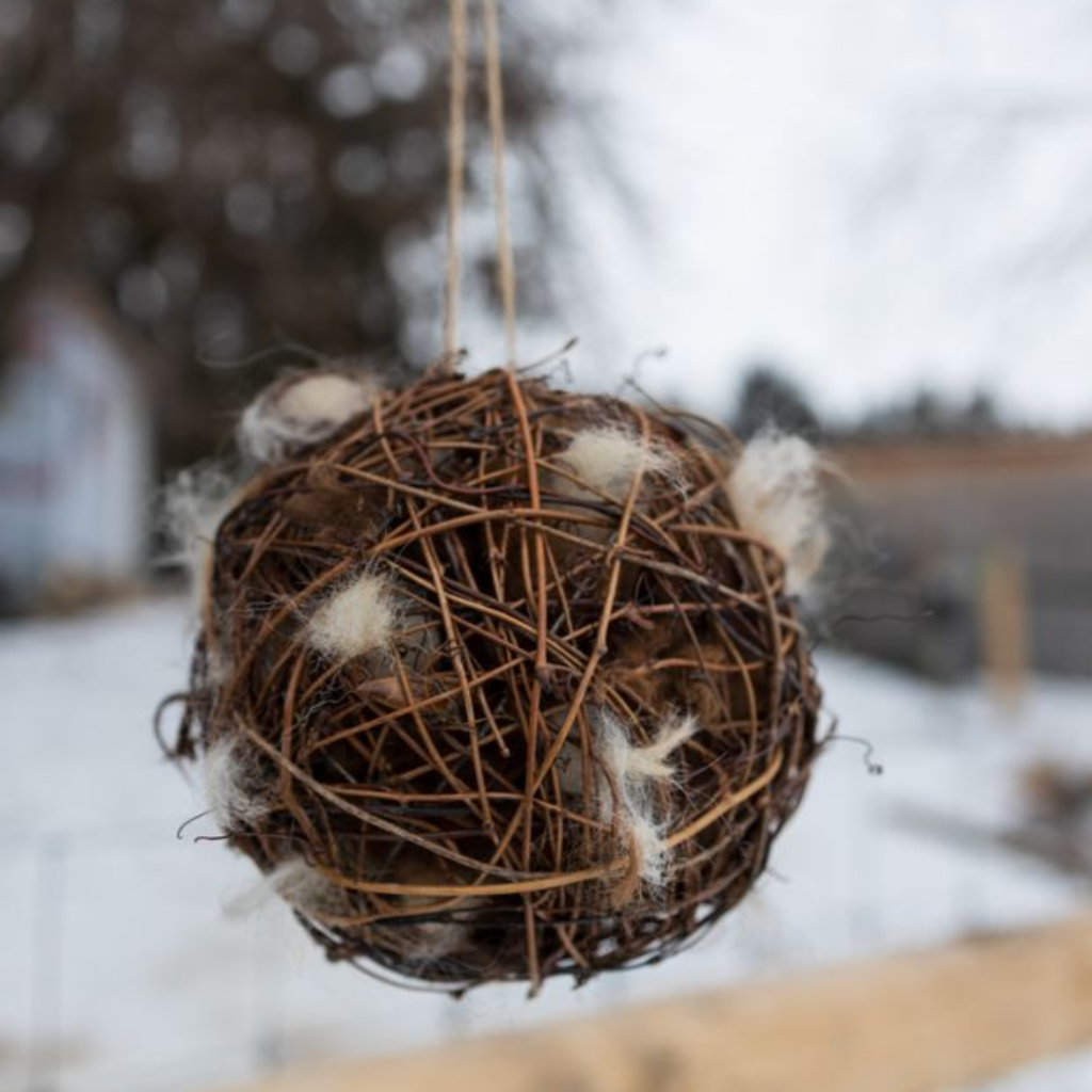 Completed fibre nesting ball made with alpaca fleece, hanging outdoors during the Alpaca Experience and Fibre Nesting Ball Workshop at Udderly Ridiculous Farm Life.
